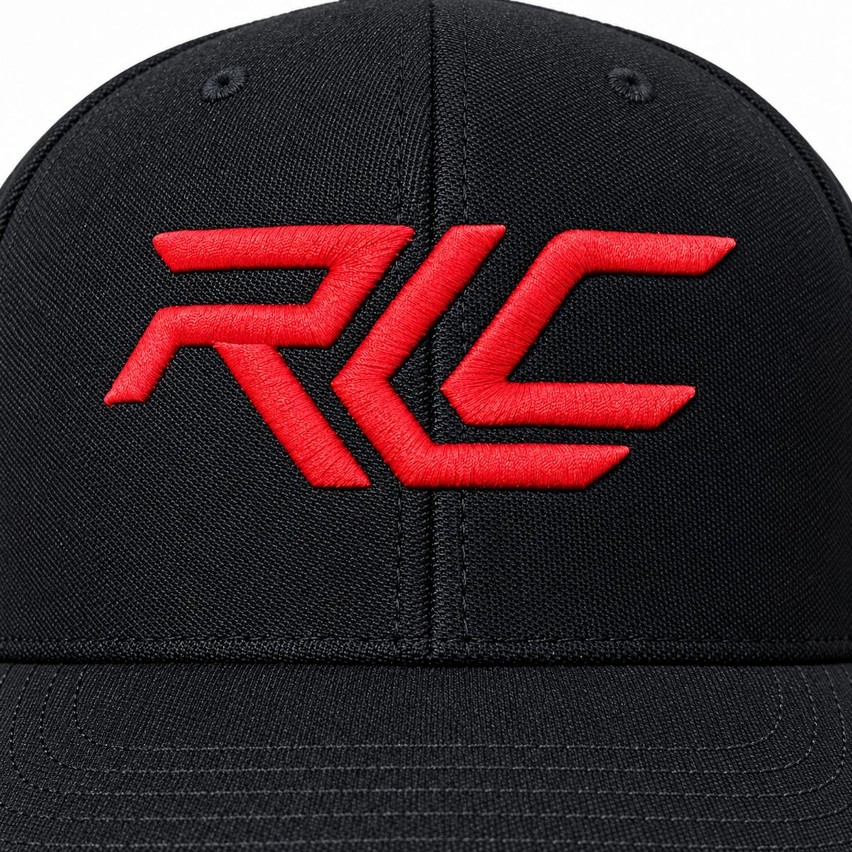 A close-up of a black baseball cap featuring a bold red embroidered 'RCL' logo on the front panel.