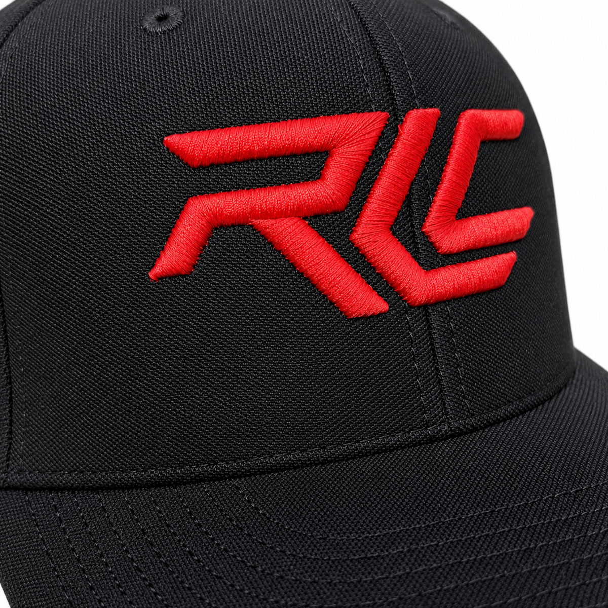 Close-up of a black structured baseball cap with a bold red embroidered 'RLC' logo on the front panel.