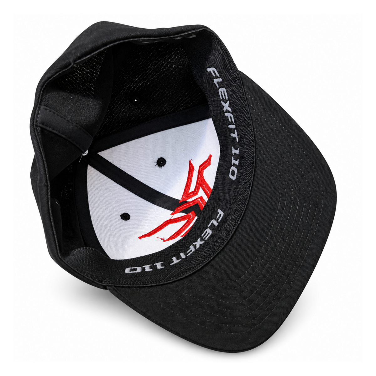 Black structured baseball cap shown from an angled top view, featuring a white inner crown with a red graphic logo and white 'FLEXFIT 110' text printed along the inner band.